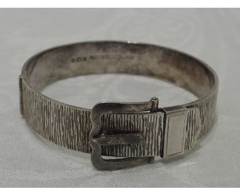 An HM silver bangle modelled as a belt with hinged buckle clasp