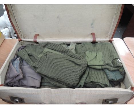 A suitcase containing army shirts, trousers and jumpers