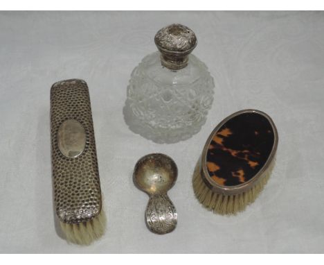 A small selection of HM silver including two clothes brushes, a spherical cut glass perfume bottle with silver collar and lid