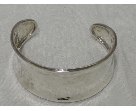A white metal cuff bangle having a plannished finish, stamped 925