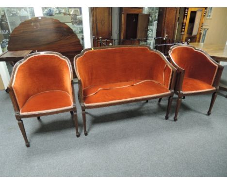 An Edwardian mahogany frame salon suite comprising pair of tub armchairs having line inlay decoration and later russet uphols