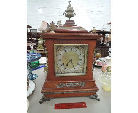 A late 19th century mahogany cased mantel clock having brass applique and spandrel Roman numeral dial with striking movement,
