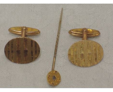 A pair of 9ct gold cufflinks having engine turned stripe decoration and fixed bar connectors, and a yellow metal stick pin st