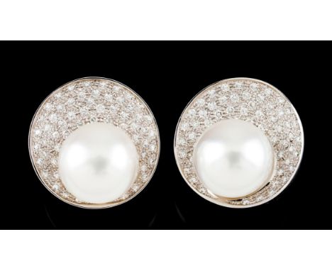 A pair of earringsGold Dome shaped set with brilliant cut diamonds pavé and two button shaped Australian pearls (ca. 14mm) De