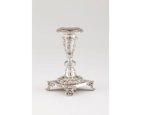 A low candle stickPortuguese silver, 19th century Engraved shaft of foliage and floral decoration on a circular foot of ident