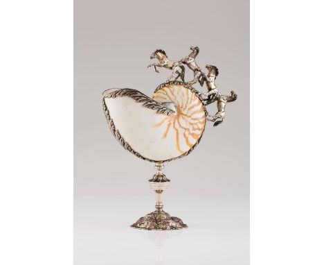 A nautilus shellSilver mounted Moulded and engraved foliage friezes and sculpted horses Tall turned foot resting on a texture