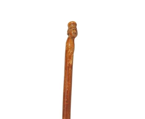 AN EARLY 19TH CENTURY CARVED WALKING STICK modelled as a head of an old lady on a notched branchwork stick97cm overall