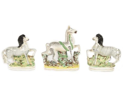 A PAIR OF 19TH-CENTURY STAFFORDSHIRE ZEBRAS AND A SIMILAR LARGER EXAMPLE26.5cm and 22cm high, 16.5cm acrossViewed under UV li
