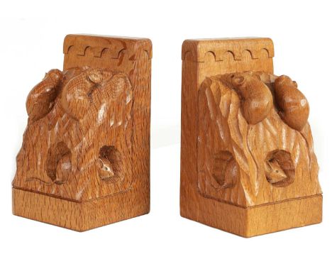 AN UNUSUAL PAIR OF ROBERT ‘MOUSEMAN’ THOMPSON TRIPLE MICE ADZED OAK BOOK ENDS of honey coloured angular form with arcaded top