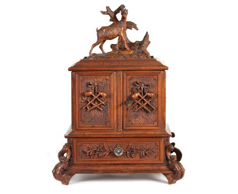 A 19TH CENTURY CARVED WALNUT BLACK FOREST CIGAR CABINET with standing deer and tree stump crested top above a pair of hinged 