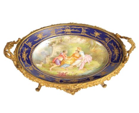 A LATE 19TH CENTURY SERVES STYLE OVAL ORMOLU MOUNTED CENTREPIECE with a painted classical figure scene to the centre surround