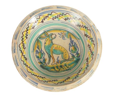 AN EARLY SPANISH LEBRILLO CERAMIC CHARGER with polychrome coloured decoration depicting a dog to the centre within zig zag de