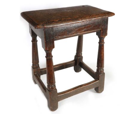 A LATE 17TH CENTURY OAK JOINT STOOL the moulded rectangular top on tapering ring turned legs with square feet joined by under