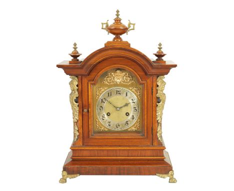 A LATE 19TH CENTURY GERMAN JUNGHANS WALNUT MANTEL CLOCK with arched brass dial having silvered chapter ring and rococo style 