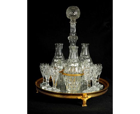 A LATE 19TH CENTURY FRENCH ORMOLU AND CUT GLASS DECANTER SET with three bulbous cut glass decanters and stoppers, together wi