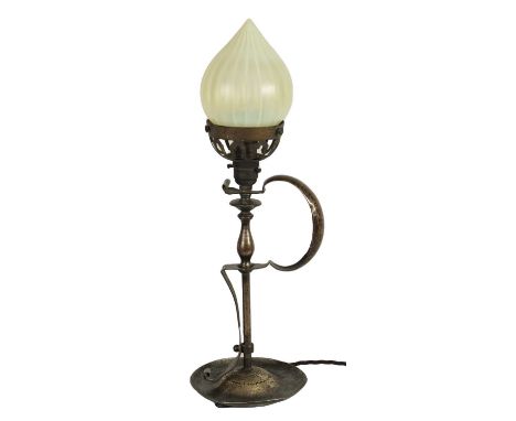 A PATINATED BRASS ART AND CRAFTS TABLE LAMP WITH VASELINE GLASS SHADE surmounted by a cone-shaped shade above a baluster turn