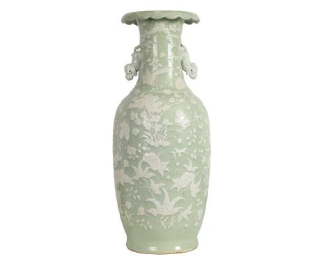 A LARGE 19TH CENTURY CHINESE RELIEF DECORATED CELADON VASE with a scalloped rim and foo dog side handles, the body decorated 