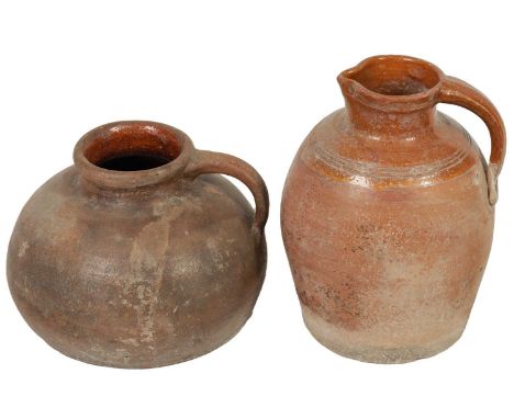 TWO EARLY CONTINENTAL TERRACOTTA POTTERY JUGS one of squat bulbous shape with side handle the other an Ayala glazed pitcher.3