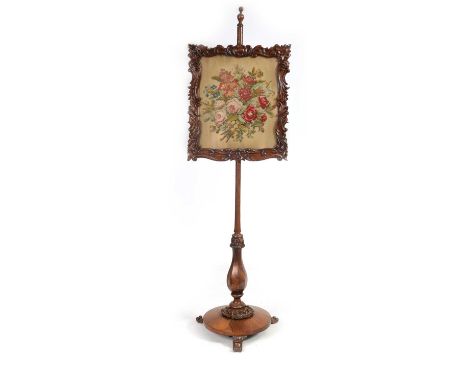 A 19TH CENTURY ROSEWOOD POLE SCREEN with leaf carved surround and floral tapestry panel, standing on a leaf carved circular b