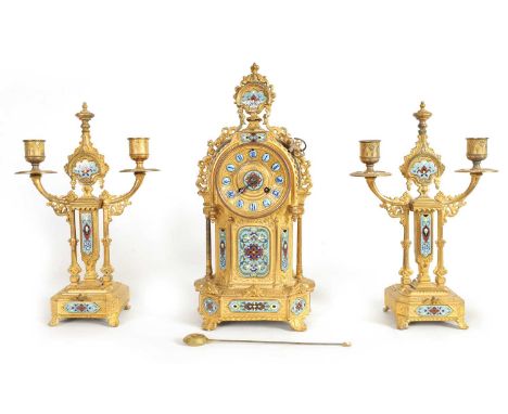 A LATE 19TH CENTURY FRENCH GILT METAL AND CHAMPLEVE ENAMEL CLOCK GARNITURE the clock with blue enamel Roman numerals fronting