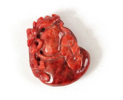 A CHINESE RED JADE CARVED AND PIERCED SCULPTURE modelled with an animal and flower5.5cm high 