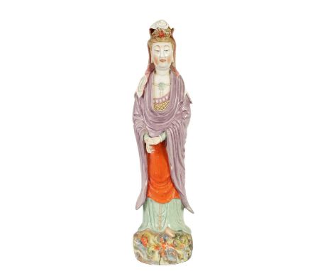 A 19TH CENTURY CHINESE PORCELAIN GUAN YIN STATUE decorated with polychrome colours, on a naturalistic base51cm high There are