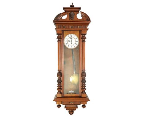 A LATE 19TH CENTURY WALNUT VIENNA STYLE WALL CLOCK having a shaped pediment above a glazed door with turned reeded columns an