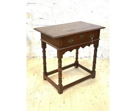 A Walnut lowboy in the 18th century style, the rectangular plank top over frieze drawer and shaped apron, raised on bobbin tu