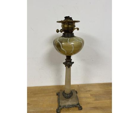 A late 19th early 20thc oil lamp the glass reservoir of veined design on stone column base with metal mounts and feet measure