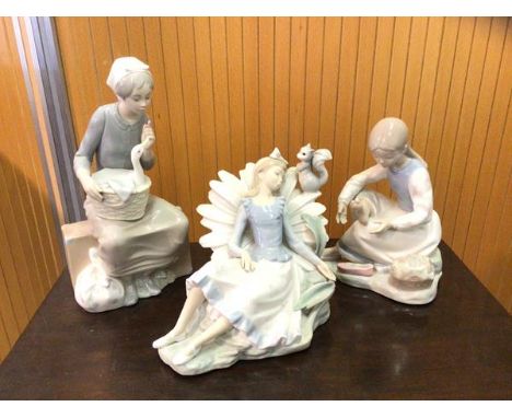 A group of three Nao figures including girl on suitcase with duck in basket measures 27cm high, girl reclining with squirrel 