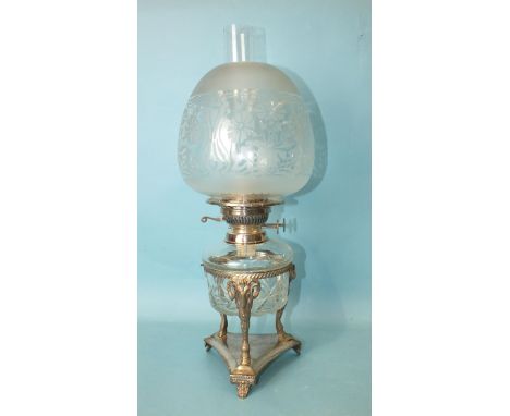 A silver-plated oil lamp, the cut-glass reservoir with plated burner by E J Shaw &amp; Co, on ram's head and hoof supports, t