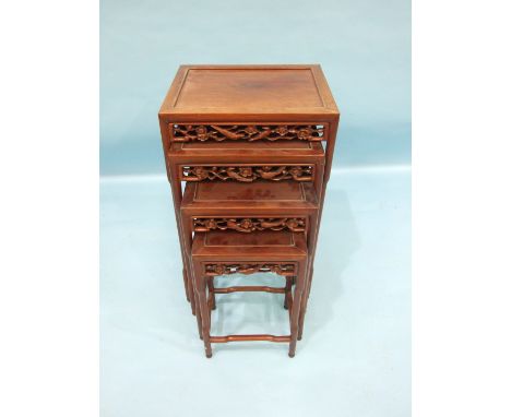 A nest of four carved hardwood Oriental graduated tables, each frieze carved with birds and prunus, on 'bamboo' legs turned a