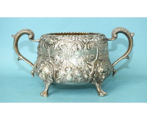 A two-handled sugar basin profusely-decorated and chased with foliage, raised on cast mask feet, with Bastard coat of arms, p