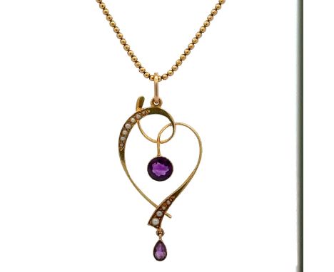 An Edwardian art nouveau amethyst and seed pearl pendant with chain. Pendant stamped 15ct and set with central round amethyst
