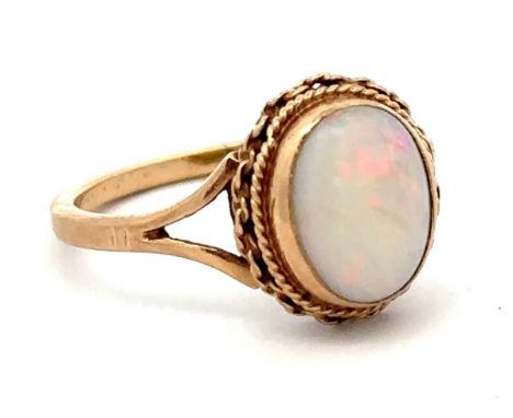 An opal ring in 9ct gold with rope twist surround.  Birmingham hallamrks. Size P.  Total weight 3.03g. Opal in good condition