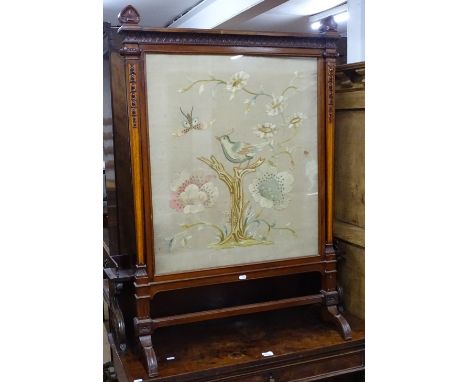 A late Victorian carved mahogany-framed firescreen, with inset needlework panel behind glass, height to top rail 3'6" 