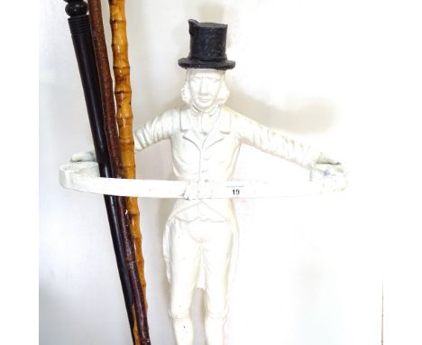 A cast-iron painted figure design stick stand with drip tray, walking cane with antler handle, a turned ebony walking stick, 