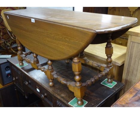 An Ercol elm drop leaf coffee table, on turned legs, W105cm 