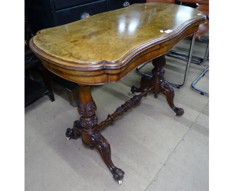 A Victorian figured walnut fold over card table, on carved stretcher base 