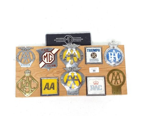 A display of Vintage car badges on pine mount 