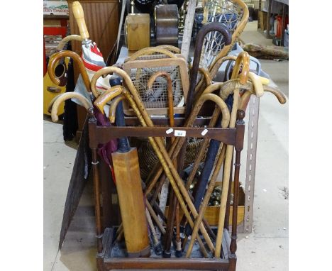 A mahogany stick stand with turned supports, containing walking sticks, tennis rackets, umbrella etc 