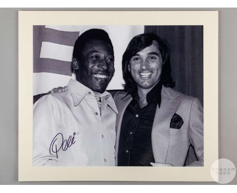 A large black and white photographic print of Pele and George Best, signed in black pen to the front by Pele with a certifica