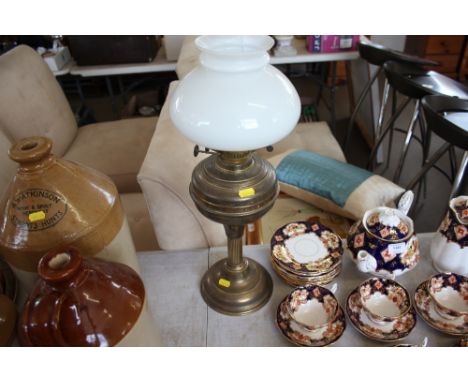 A brass oil lamp with milk glass shade