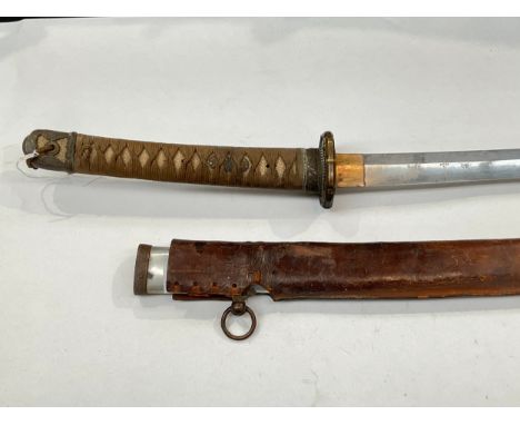 A WWII Japanese katana, the rayskin wrapped grip joining a bronze tsuba with floral relief, the blade measuring approximately