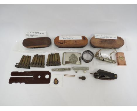 A collection of various military collectibles including cigarette lighter, belt buckle, Bakelite button polisher etc