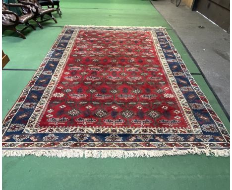 Large Turkish red ground hand knotted wool carpet with geometric patterns, 346 x 264cms. Estimate £120-140.