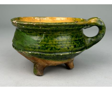 A EUROPEAN CERAMIC BOWL WITH HANDLE ON TRIPOD FEET PROBABLY 16TH CENTURY Found in a Dutch canal, 12.5cm x 8cm
