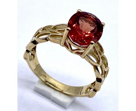 A 10K/375 gold dress ring set with red quartz, Size N 1/2, 2.7 grams total.