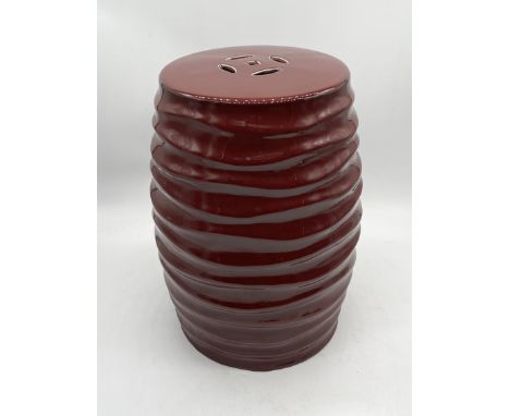 A Chinese style red ceramic stool with ridged detail - height 52cm