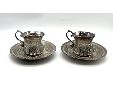 A pair of Eastern silver cups and saucers decorated with swags, both with vacant cartouches, total weight 541g